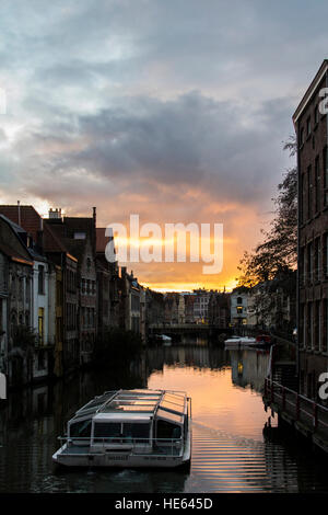 Einen ruhigen, romantischen Abend in Gent, Belgien. Fabelhaften Sonnenuntergang in der Nähe des Kanals. Schöne Architektur und touristischen Boot. Stockfoto