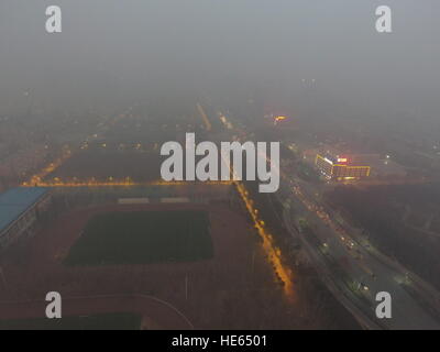 Zhengzhou, Zhengzhou, China. 18. Dezember 2016. Zhengzhou, CHINA-Dezember 18 2016: (nur zur redaktionellen Verwendung. CHINA HERAUS). Die schweren Smog hüllt Zhengzhou, Hauptstadt der Provinz Zentral-China Henan, 18. Dezember 2016. Die schlimmste Luftverschmutzung so weit in diesem Winter setzte sich in Bewegung in nördlichen Regionen von China einschließlich Henan, Shandong, Shanxi, Hebei, Tianjin und Peking am 16. Dezember und wird voraussichtlich innerhalb von fünf Tagen dauern. Großalarm für die Luftverschmutzung wurde herausgegeben und Sofortmaßnahmen ergriffen, um dem Smog zu bekämpfen. © SIPA Asien/ZUMA Draht/Alamy Live-Nachrichten Stockfoto