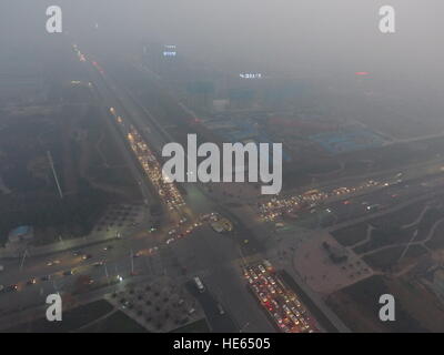 Zhengzhou, Zhengzhou, China. 18. Dezember 2016. Zhengzhou, CHINA-Dezember 18 2016: (nur zur redaktionellen Verwendung. CHINA HERAUS). Die schweren Smog hüllt Zhengzhou, Hauptstadt der Provinz Zentral-China Henan, 18. Dezember 2016. Die schlimmste Luftverschmutzung so weit in diesem Winter setzte sich in Bewegung in nördlichen Regionen von China einschließlich Henan, Shandong, Shanxi, Hebei, Tianjin und Peking am 16. Dezember und wird voraussichtlich innerhalb von fünf Tagen dauern. Großalarm für die Luftverschmutzung wurde herausgegeben und Sofortmaßnahmen ergriffen, um dem Smog zu bekämpfen. © SIPA Asien/ZUMA Draht/Alamy Live-Nachrichten Stockfoto