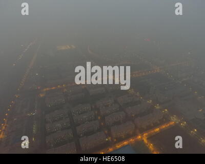 Zhengzhou, Zhengzhou, China. 18. Dezember 2016. Zhengzhou, CHINA-Dezember 18 2016: (nur zur redaktionellen Verwendung. CHINA HERAUS). Die schweren Smog hüllt Zhengzhou, Hauptstadt der Provinz Zentral-China Henan, 18. Dezember 2016. Die schlimmste Luftverschmutzung so weit in diesem Winter setzte sich in Bewegung in nördlichen Regionen von China einschließlich Henan, Shandong, Shanxi, Hebei, Tianjin und Peking am 16. Dezember und wird voraussichtlich innerhalb von fünf Tagen dauern. Großalarm für die Luftverschmutzung wurde herausgegeben und Sofortmaßnahmen ergriffen, um dem Smog zu bekämpfen. © SIPA Asien/ZUMA Draht/Alamy Live-Nachrichten Stockfoto