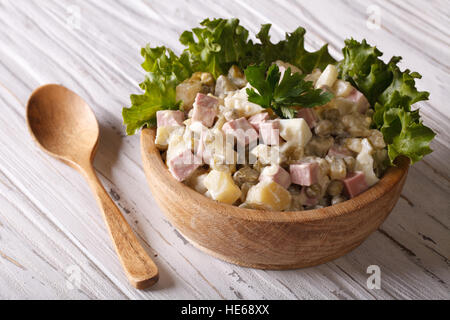 Russischer Salat hautnah in einer hölzernen Platte auf den Tisch. horizontale, rustikalen Stil Stockfoto