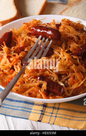 gedünstetem Kohl mit Wurst Nahaufnahme in weißen Teller. vertikale Stockfoto