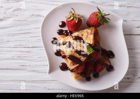 Crepes mit Erdbeeren und Schokolade auf dem Tisch. Horizontale Ansicht von oben Stockfoto