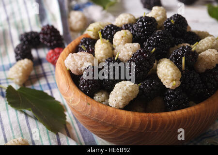 Reife weiße und schwarze Maulbeeren in einer Holzschale auf der Tabelle Nahaufnahme. horizontale Stockfoto