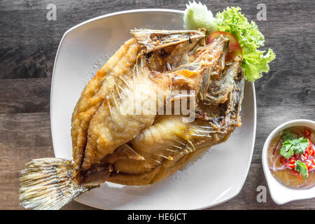 Fritierter Wolfsbarsch mit Fischsauce und würziger Salat Stockfoto