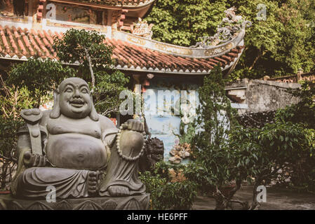 Jolly chubby Buddha Statue vor der kleinen buddhistischen Tempel auf Marmor Berge in der Nähe von Da Nang, Vietnam Stockfoto