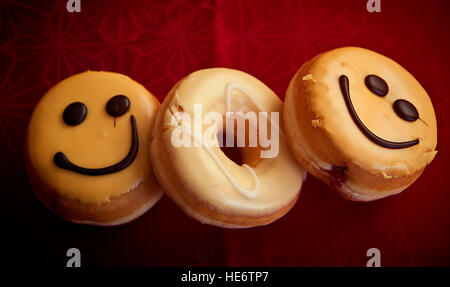 Krapfen mit glasierten Sahne und Schokolade Smiley Dekoration Stockfoto
