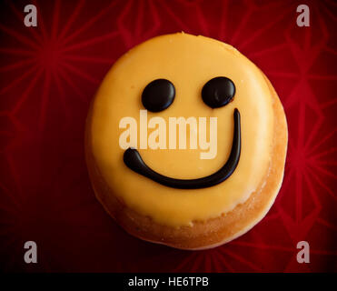 Smiley-Krapfen mit Zitronenglasur Sahne und Schokolade Stockfoto