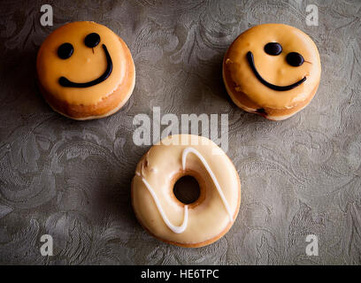 Krapfen mit glasierten Sahne und Schokolade Smiley Dekoration Stockfoto