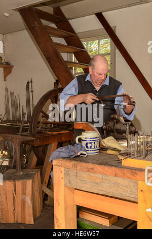 Dolmetscher-Handwerker arbeitet in Colonial Williamsburg Büchsenmacher-Shop. Stockfoto