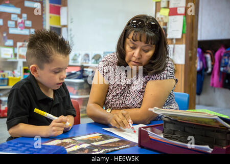 Thoreau, New Mexico - Klassenzimmer Assistentin Jennifer Vandever arbeitet mit einer Studentin in einem Kindergarten Klassenzimmer am St. Bonaventure Indian School Stockfoto