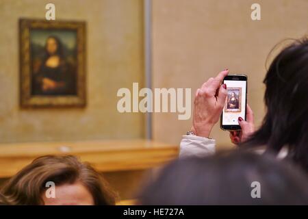 Besucher nehmen Selfie Bilder auf ihren Handys vor der Mona Lisa (La Joconde) Gemälde von Leonardo da Vinci im Louvre Stockfoto