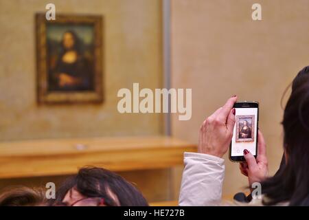 Besucher nehmen Selfie Bilder auf ihren Handys vor der Mona Lisa (La Joconde) Gemälde von Leonardo da Vinci im Louvre Stockfoto