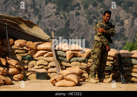 Ein Afghan National Army Soldat schaut zu, wie ein Mi-17 Hubschrauber Lieferungen entlädt 8. Juli 2012, am Barg-e-Matal, ein Außenposten in der Provinz Nangarhar, Ost-Afghanistan. Die gemeinsame Mission der afghanischen Luftwaffe und der US Air Force Mi-17 Hubschrauberbesatzungen war, afghanischen Streitkräfte an remote-Standorten zu versorgen.  Staff Sgt Quinton Russ Stockfoto