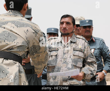 Afghanischen Grenze Polizei Major General Tafsir Khan, Kommandant, 3. Zone ABP gratuliert ein Absolvent von der afghanischen Grenze Polizei-Grundkurs im Spin Boldak ABP Training Center, 27. August 2011, bei Spin Boldak, Afghanistan. Einhundertdreißig afghanischen Grenze Wilderer absolvierte die Klasse, die war der erste Versuch der acht-Wochen-Kurs (vorherige Rekruten ausgebildet für sechs Wochen), und ist auch der letzte aus dem Spin Boldak Center zu absolvieren. Stockfoto