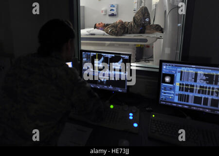 US Air Force Staff Sgt Brandy Bisson, diagnostische Bilder eine Computertomographie-Scan Techniker überprüft die CAT-Scan-Bilder der US Armee Sgt. Karl Berlinger rechten Fuß 12. Februar 2014, Landstuhl Regional Hospital, Deutschland. Berlinger erhielt Behandlung für seine Verletzungen an LRMC innerhalb einer Stunde nach der Ankunft von Bagram Air Field, Afghanistan. Senior Airman Chris Willis) Stockfoto