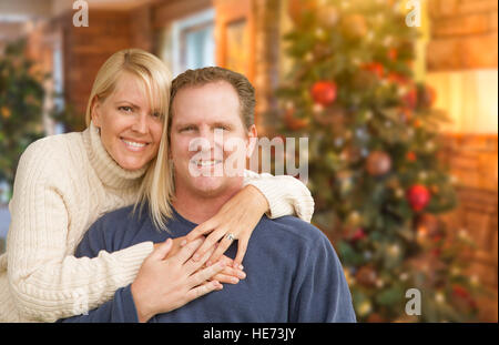 Glücklich liebende kaukasischen paar Portrait vor Weihnachtsbaum im Innenbereich. Stockfoto