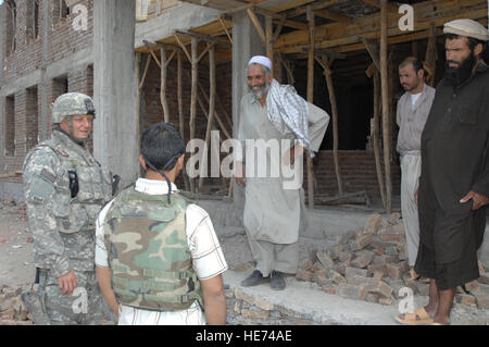 Captain Harry Jackson, ein Bauingenieur-Qualitätskontrolle-Offizier, Gespräche mit Bauarbeiter am Nilay Boys und Girls School in Kohi Safi, bei einem Besuch vor Ort durch das Provincial Reconstruction Team bei Bagram Airfield, Afghanistan, am 6. August. Das Team geht an lokale Bereiche, Bau-Projekt-Websites zu bewerten. Stockfoto