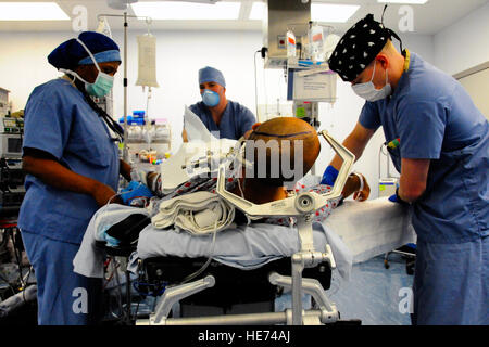 U.S. Air Force Maj Clara Batiste, Certified Registered Nurses Assistant Capt Michael Tiger, ein Anästhesist und Maj Jonathan Forbes, Neurochirurg, 455. Expeditionary Medical Operations Squadron bereitet ein Patient für Hirn-OP bei Craig Joint Theater Hospital, Bagram Air Field, Afghanistan, 10. Oktober 2014.  Forbes einen 8 Zentimeter Tumor entfernt ist das Gehirn des Patienten. Batist wird bereitgestellt von Fort Sam Houston, Texas.  Forbes und Tiger sind von Travis Air Force Base, Kalifornien eingesetzt.   Staff Sgt Miguel Lara III Stockfoto