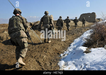 Mitglieder der 777th Expeditionary Prime BEEF-Staffel und die 755. Expeditionary Sicherheit Kräfte Squadron Reisen zur Behebung der defekten Brunnen in Dörfern in der Nähe von Bagram Air Field, Afghanistan, 26. Januar 2013.  Diese Flieger reiste zu Fuß in kleinen Gruppen über Feldwege und mussten alle ihre Werkzeuge und Geräte von hand zusammen mit ihren Waffen zu tragen.  Senior Airman Chris Willis) Stockfoto