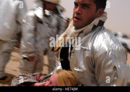 Staff Sgt Abraham Lara, Crewchief, 407th Expeditionary Civil Engineer Squadron-Feuerwehr, unterstützt bei der US Army Opfer einer simulierten Flugzeugabsturz Aug. 6 zu transportieren. Das Flugzeug Notfall und die verletzten Opfer wurden in Verbindung mit einer mass Casualty Übung eingesetzt, um die Fähigkeiten der Einsatzkräfte wie Sgt. Lara zu bewerten. Sgt. Lara wird hier von Eglin Air Force Base, Florida, bereitgestellt und stammt aus El Paso, Texas. Stockfoto