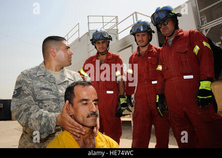 Bagdad, Irak--Air Force Tech SGT Essam Cordova, 821st Expeditionary Training Squadron Feuer und Berater zu retten, hat das Ziel irakischer Feuerwehrmann wie Sie manuell die Halswirbelsäule des Patienten zu stabilisieren und Messen für ein C-Wirbelsäule Halsband hier 9. August 2009. Er lehrt Verfahren bei fortgeschrittenen Rettung mit Auto-Bergung an Studenten in der internationalen Zone. Sergeant Cordova wird bereitgestellt von Goodfellow Air Force Base, Texas, und ist gebürtig aus Queens, N.Y.  Techn. Sgt. Johnny L. Saldivar Stockfoto