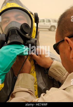 Techn. Sgt. Peter Mickiewicz, 447th Expeditionary Bauingenieur-Geschwader, sichert ein Stück chemische Klebeband um die Maske des Senior Airman Tyrone Fisher, 447th ECES Camp Stryker, Irak 24. April 2009. Alle Nachrichten, die in Bagdad, die nicht ordnungsgemäß beschriftet kommt, keine Absenderadresse oder verliert sich im System muss überprüft werden, bevor sie verarbeitet werden und an das gewünschte Ziel zu bekommen. Die irakische Regierung liefert die Post zum gemeinsamen militärischen Mail Terminal auf treu und glauben, aber das Militär hier hat, die notwendigen Vorkehrungen zu treffen, weil die Post den militärischen Post-Syste links Stockfoto