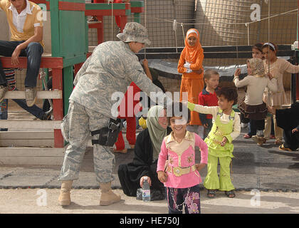 Mitglied US Air Force Sicherheit Kräfte aus der 586th Air Expeditionary Gruppe spielt mit irakische Kinder am 29. September 2008, im Camp Bucca, Irak, während sie warten, bis der Häftling Besuchsrecht Zimmer. 586th AEG bietet Sicherheit und Transport zum Zentrum für fast 400 Besucher, die täglich mit Inhaftierten in der Theater-Internierung-Einrichtung besuchen dürfen. Stockfoto