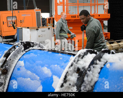 Flieger 1. Klasse Pascal Dieujuste, 786th Civil Engineer Squadron Heavy Equipment Operator, reinigt einen Pflug, nachdem das Geschäft den ersten Schnee der Saison aus der Flightline 3. Dezember 2014, bei Ramstein Air Base, Germany gelöscht.  Dieujuste und ein Team der Flieger begann in den frühen Morgenstunden um sicherzustellen, dass Ramstein Flugzeuge starten halten kann. Senior Airman Armando A. Schwier-Morales) Stockfoto