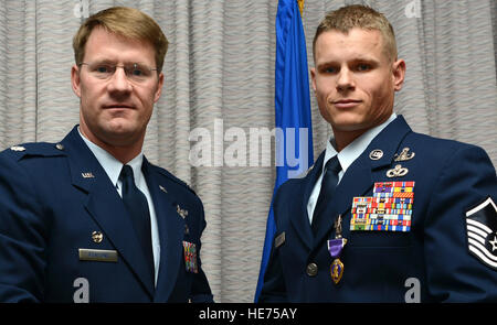 Oberstleutnant Trevor Benitone, Kommandant der United States Air Force Operations Sonderschule, posiert für ein Foto mit Master Sgt. Ronnie Brickey, USAFSOS Force Protection Zweig NCO in Kosten, danach präsentiert ihn mit dem Purple Heart 20. Februar 2014, in Hurlburt Field, Florida Dies ist der zweite Purple Heart Brickey erhielt im Laufe seiner Karriere der Luftwaffe in explosiver Kampfmittel zur Verfügung. Stockfoto