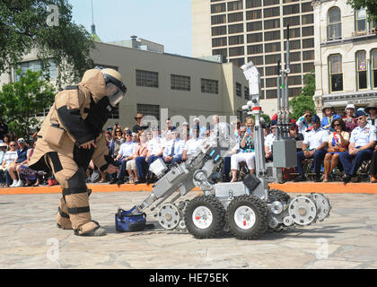 Senior Airman Corey Mcenery, 502. Civil Engineer Squadron Explosive Ordnance Disposal Techniker auf gemeinsamer Basis San Antonio-Lackland, zeigt die Verwendung von Bombe Anzug und Roboter als Teil der Bombe Entsorgungsverfahren während Luftwaffe bei Alamo Veranstaltungen in Verbindung mit Fiesta San Antonio April 20. Der Anzug wiegt etwa 80 Pfund und Flieger aus Sprengstoff an einen Arm Länge, oder ungefähr 3 Fuß schützt. Der Roboter wird verwendet, um die Flieger sicher in einem größeren Abstand zu halten und zu überprüfen und entfernen ein verdächtiges Paket verwendet werden kann.   Melissa Peterson/released) Stockfoto