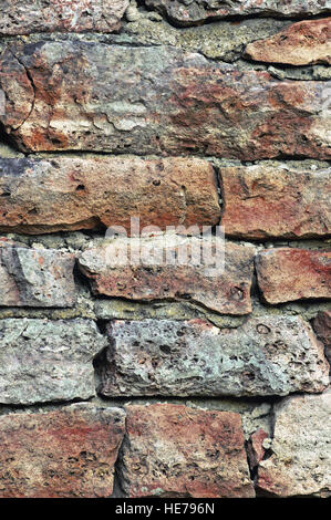 Steinmauer Makro Nahaufnahme, stonewall Muster Hintergrund, vertikale, alt gealtert verwitterten roten und grauen Grunge Kalkstein Dolomit Calciumcarbonat Stockfoto