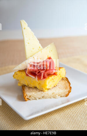 Spanische Tapas Manchego Käse, Iberico-Schinken und spanisches Omelett auf geschnittenem Brot gemacht. Stockfoto