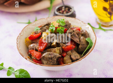 Gebratene Geflügelleber mit Äpfeln und Paprika in Schüssel Stockfoto