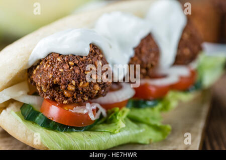 Frische Falafel Sandwich gemacht (close-up erschossen; selektiven Fokus) auf einem alten Holztisch Stockfoto