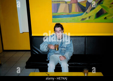 junge männliche Touristen Cannabis Tee trinken in der sanften gelb Kaffee shop Amsterdam der 1990er Jahre Stockfoto