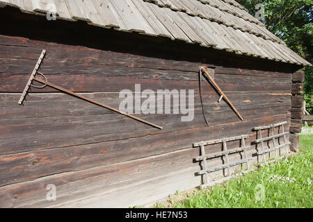 Traditionelle Handarbeit Rake und Sense auf Scheune Wand, ethnographische Park, Torun, Polen Stockfoto