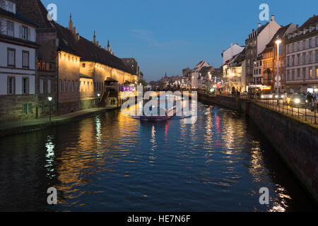 Ein Touristenboot auf dem Fluss L'ILL bei Nacht, Straßburg, Elsass, Frankreich Stockfoto