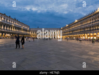 Nachtansicht des quadratischen San Marco in Venedig mit Menschen, Restaurants, Musiker. Italien. Verschwommen Stockfoto