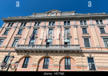 Fassade des alten schönen Gebäude mit Uhr, Balkon und Fahnen der Venedig und der Europäischen Union am Ufer des Canal Grande in Venedig, Italien. Stockfoto