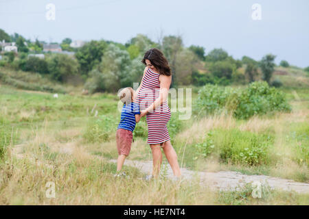 Schwangere Frau, die Landschaft mit ihrem Sohn. Stockfoto