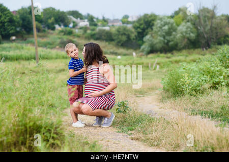 Schwangere Frau, die Landschaft mit ihrem Sohn. Stockfoto