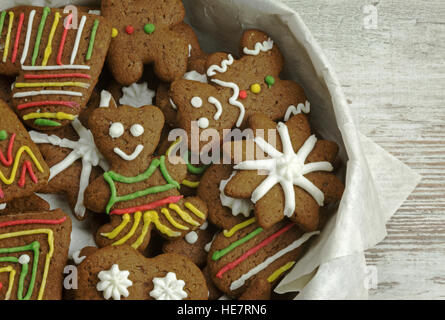 Foto von mehreren Arten von hausgemachten, handbemalt Lebkuchen in einem Behälter, gefüllt mit Backpapier Lebensmittelgeschäft mit textfreiraum auf der rechten Seite. Flach, h Stockfoto
