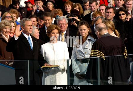 US-Präsident George W. Bush steht von seiner Familie, wie er bei seiner zweiten Amtseinführung von US Supreme Court Chief Justice William Rehnquist auf dem US-Kapitol 20. Januar 2005 in Washington, D.C. vereidigt wird. Stockfoto