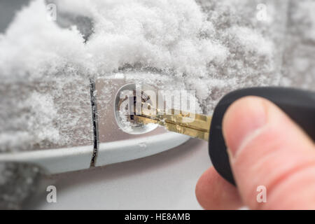 Nahaufnahme eines Schlüssels in der Schleuse von gefrorenen Autotür im Winter eingefügt Stockfoto