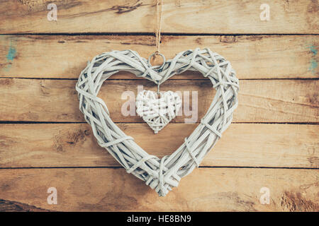 Zwei rustikale dekorative Holzherzen Vintage Holz-Hintergrund mit Raum hängen. Stockfoto