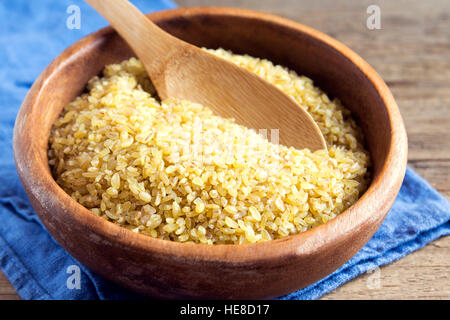 Bio Bulgur, Couscous roh Weizenkorn in Keramikschale schließen sich - gesunde Lebensmittelzutat Stockfoto