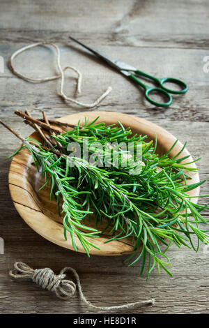 Rosmarin Blätter Haufen Nahaufnahme. Frische Bio Würze Pflanzen Rosmarin auf Holztisch mit Textfreiraum. Gewürze, Kochen, Zutaten für gesunde Stockfoto