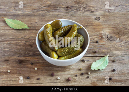 Eingelegtes Gemüse. Schüssel mit Essiggurken (Gurken) über rustikalen hölzernen Hintergrund hautnah. Stockfoto