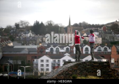 Friedensstatue „Hands Across the Divide“ in Londonderry, Nordirland, geschmückt mit Weihnachtspulern. Stockfoto